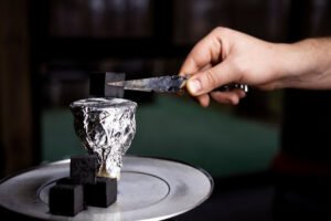 Hand gebruikt tang om hete kool op shisha-kom (hoofd) te plaatsen.